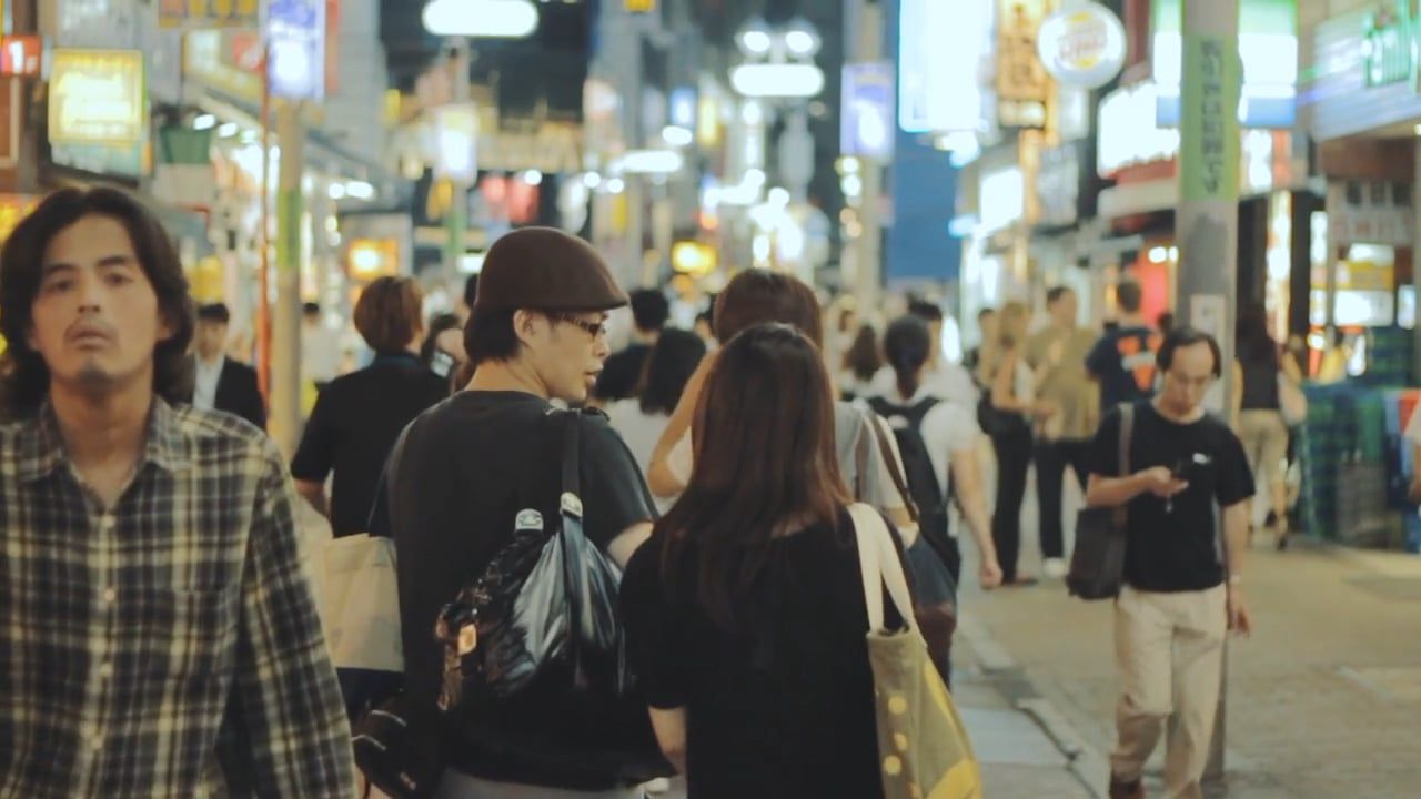 couple holding hands while walking on a busy street 6574256