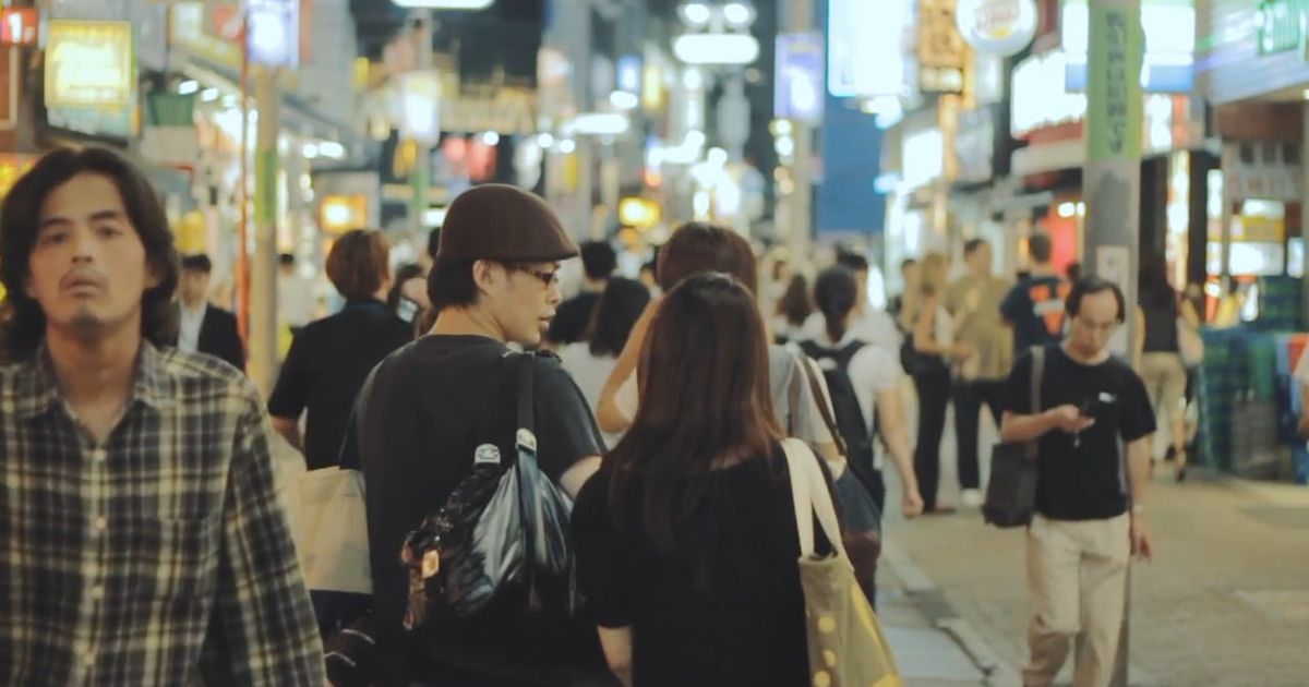 couple holding hands while walking on a busy street 6574256