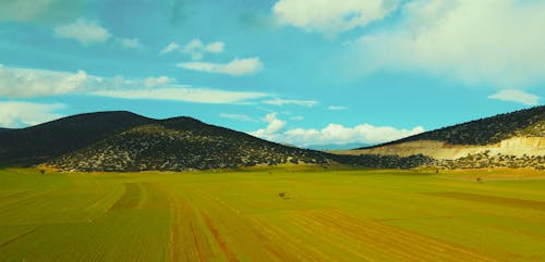 Drone Footage of Green Fields and Mountains 