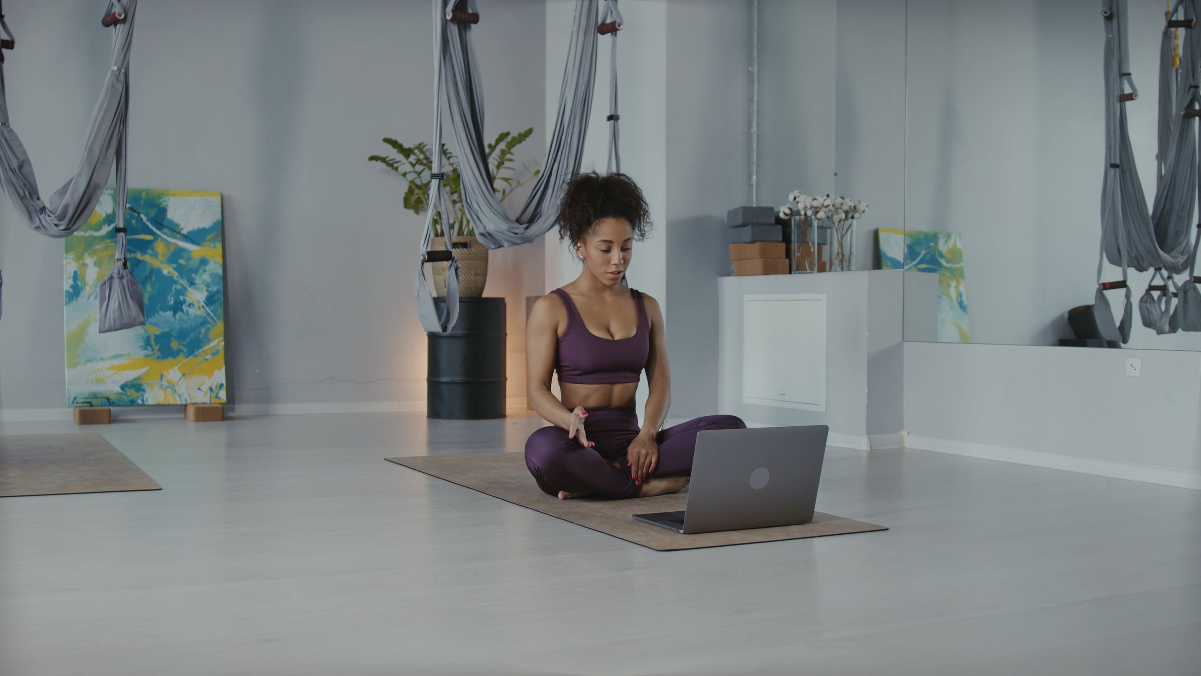 A Woman Sitting on Yoga Mat while Facing the Laptop Free Stock Video ...