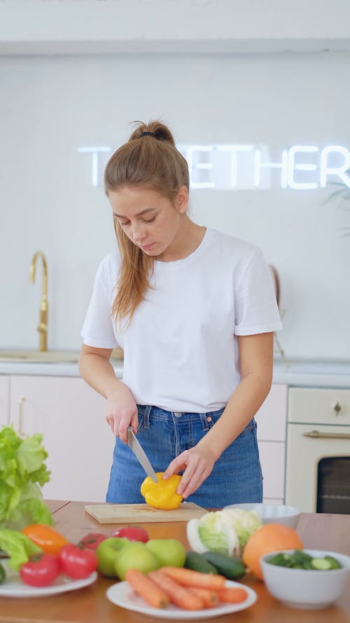 Young Woman Cutting Bell Pepper