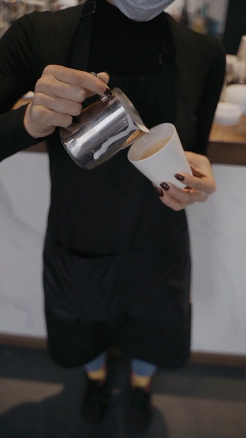 Barista Pouring Milk on Coffee