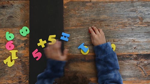 A Kid Playing with Numbers