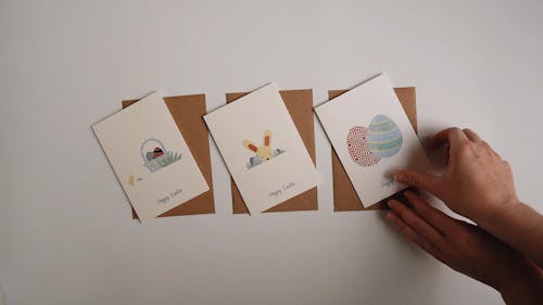 A Person Inserting the Easter Card Inside an Envelope