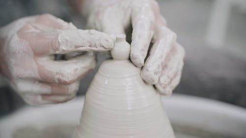 Man Creating a Miniature Vase on a Spinning Pottery Wheel