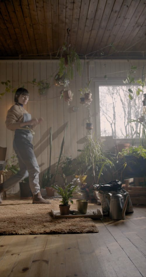 A Video of a Woman Transferring a Plant to a Bigger Pot