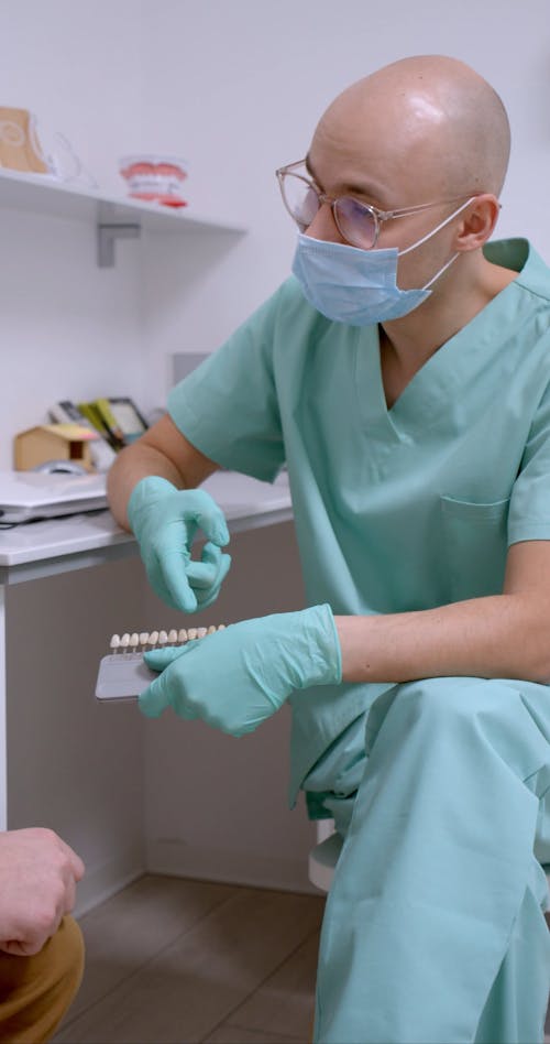 A Dentist Showing Dental Veneers to His Patient