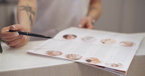 Person Pointing Services on a Brochure Using a Pen