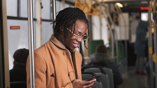 A Man Using a Smartphone Inside a Moving Train