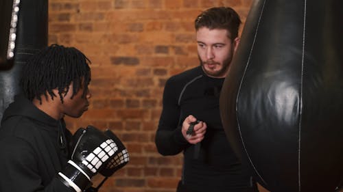 A Male Boxer Training with His Coach