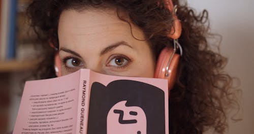A Woman Covering Half of Her Face with a Book