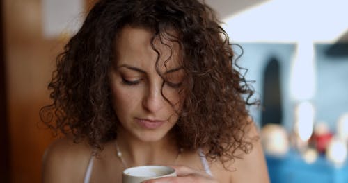 Woman with Curly Hair Holding a Cup