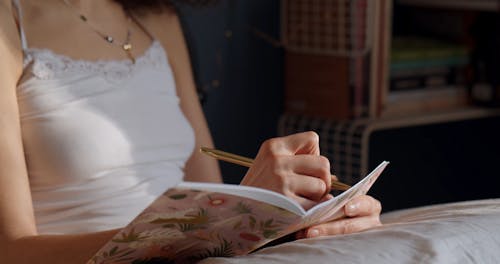 A Woman Writing on a Notebook