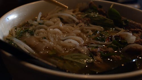 Close-Up Shot of Using Chopsticks on Noodle Soup