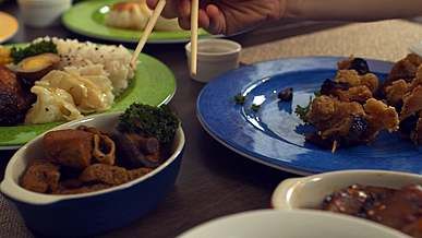 a person getting a food using a chopsticks
