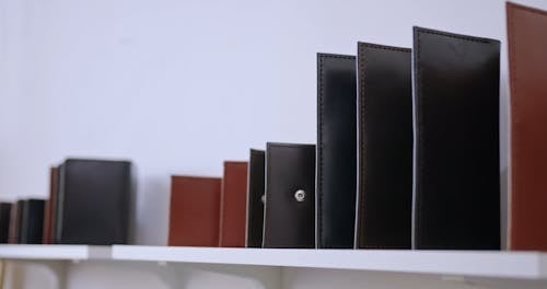 A Person Getting a Leather Wallet from a Shelf