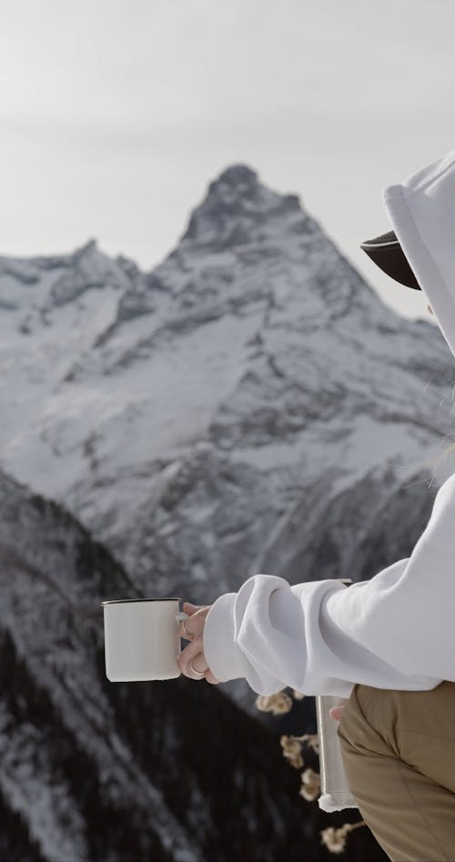 A Person Pouring Tea while on the Snow
