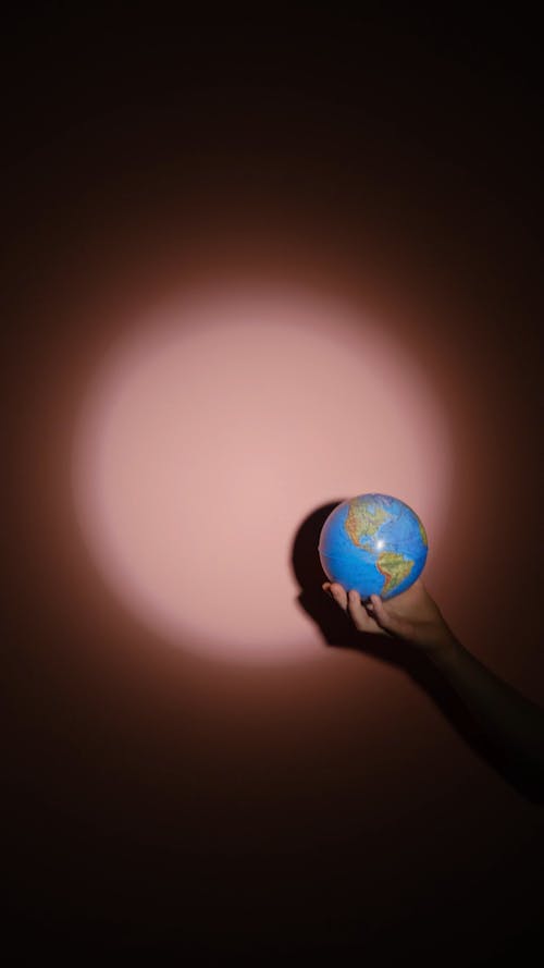 People Holding Globe On The Spotlight