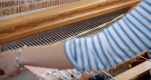 A Person Weaving while using a Loom