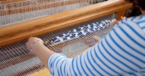 A Weaver Working using a Loom