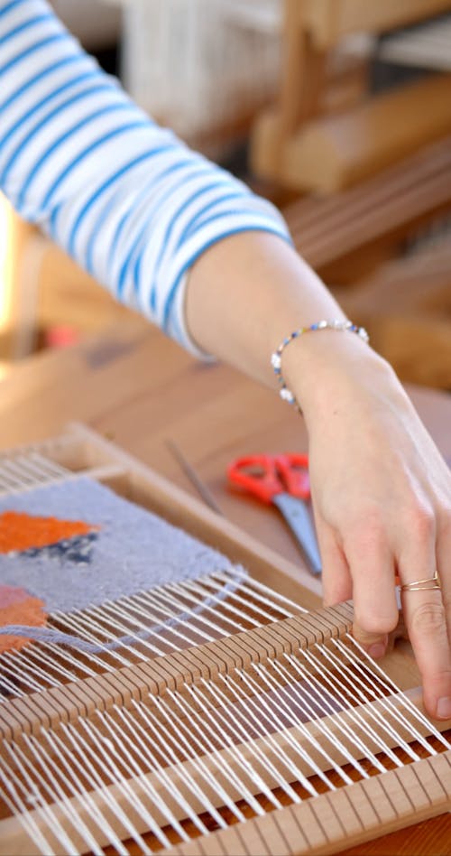 A Person Weaving using a Hand Loom