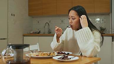a worried woman eating alone