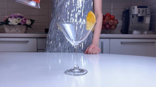 Woman Pouring a Cocktail on a Glass