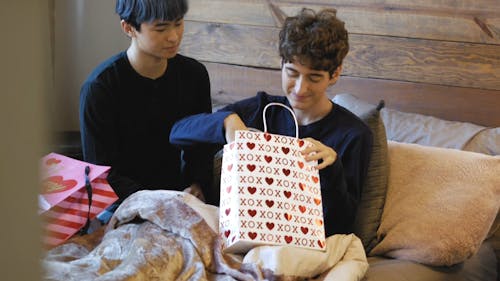A Couple Opening Gifts and Kissing