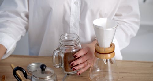 Woman Placing Coffee into Chemex Coffeemaker