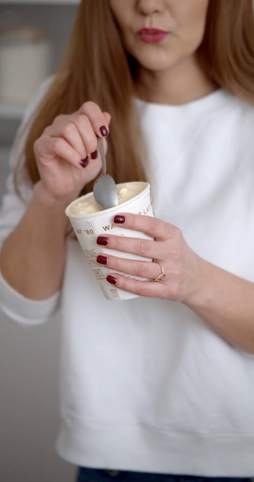 A Woman Dancing while Eating an Ice Cream