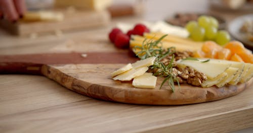 Arranging Cheese on a Wooden Tray