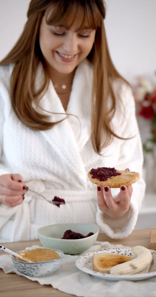 Woman Putting On Jam on her Bread