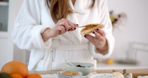 Person Putting Peanut Butter on a Bread