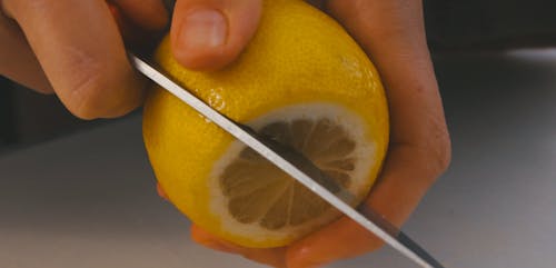 Hands Slicing a Lemon