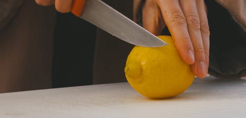 Person Slicing a Lemon