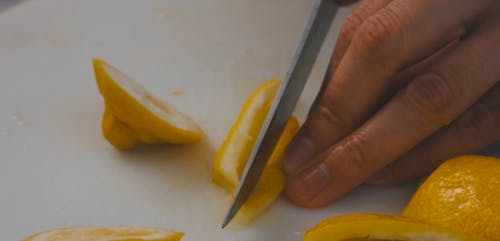 Person Slicing a Lemon Peel