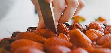 close up video of a person slicing an strawberry cake