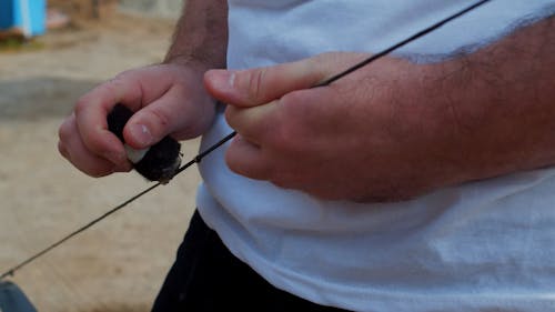 Male Hands Applying Wax to Bowstring