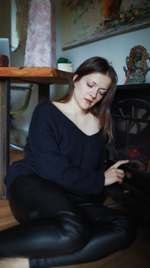 Depressed Woman Sitting by Fireplace