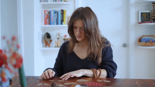 A Woman Putting Together Heart-shaped Puzzle Pieces