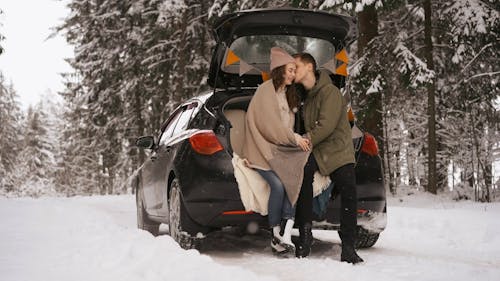 A Man Kissing His Girlfriend in Winter Forest