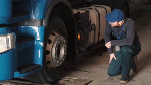 Man Checking the Wheel of the Truck 