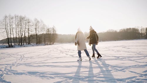 Back View of a Couple Skating in the Frozen Lake 