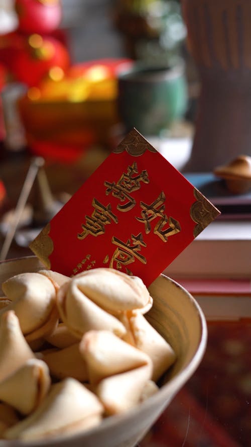 A Bowl Of Fortune Cookies With Red Envelope