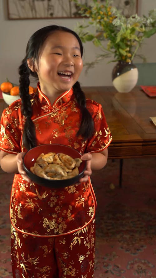 A Young Girl Holding A Bowl Of Food