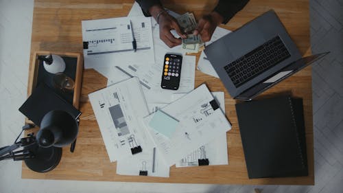 Man Counting Money on Work Desk