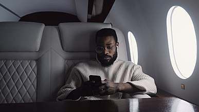 man using smartphone while travelling in private jet