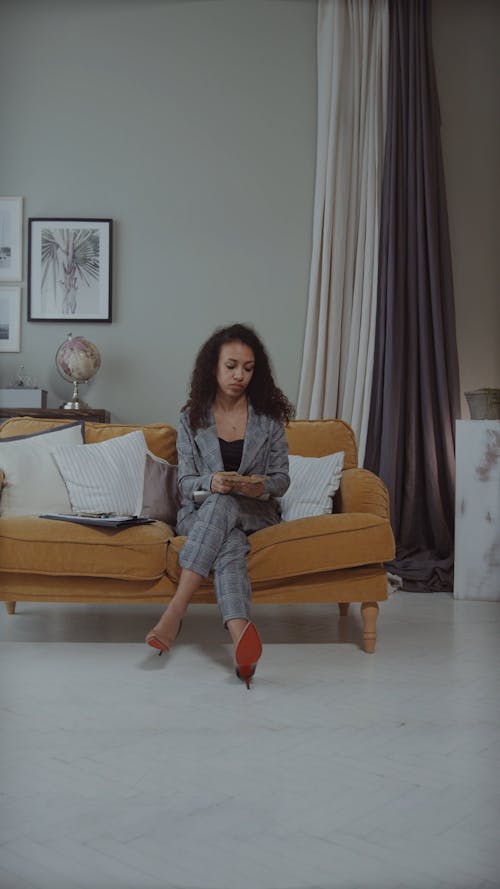 Female Sitting on the Couch Counting Money