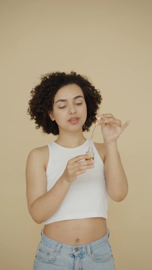 A Woman Applying Essential Oil Over Her Cheek