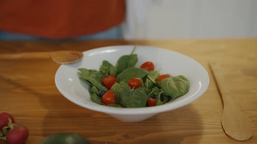 A Young Woman Preparing A Vegetable Salad